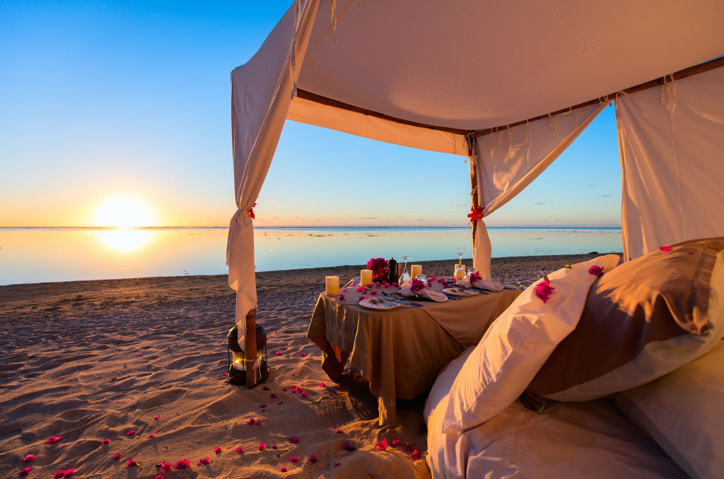Romantic luxury dinner setting at tropical beach on sunset